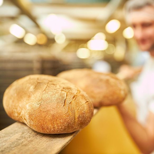 panadero con pan en bandeja de madera